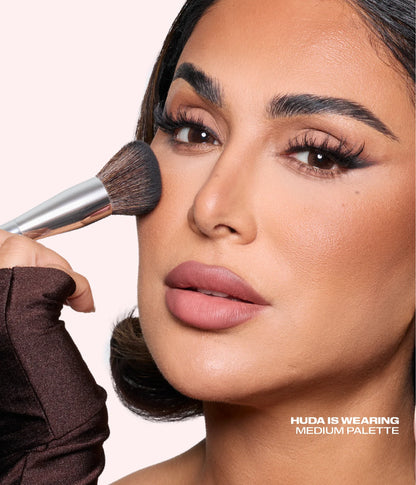 Huda Beauty founder Huda Kattan applying Bronze Filter Palette with the bronzing brush, with text 'Huda is wearing Medium palette'