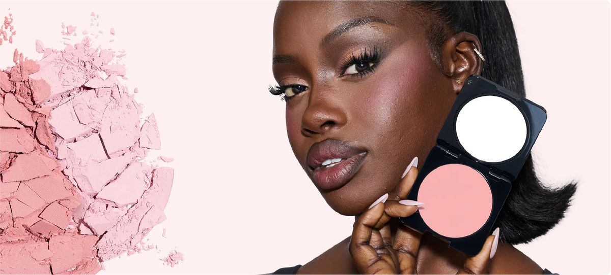 Huda Beauty model holding an open Easy Bake Pressed Powder compact beside her face with crumbled pink powder behind her, find your shade banner
