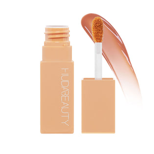 Huda Beauty Lip Blush in Peachy Kiss, open peach tube with applicator and a glossy swatch